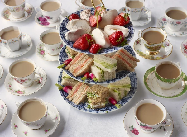 english breakfast tea in cups and sandwiches on cakestand