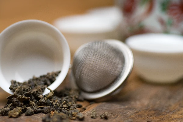 loose leaf tea and tea strainer on table