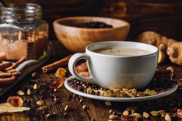 masala chai latte in white cup with different spices