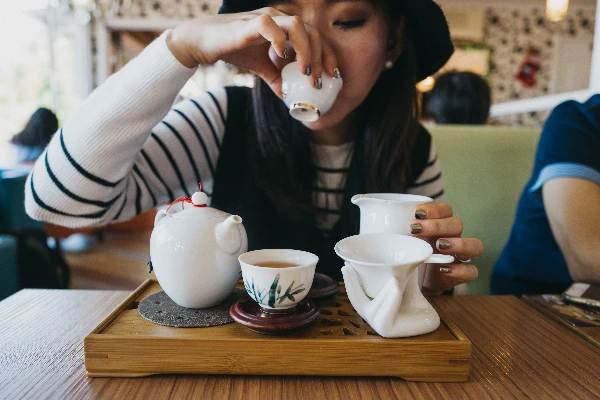 woman sipping hot tea with milk