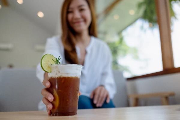 young asian woman drinking thai iced tea